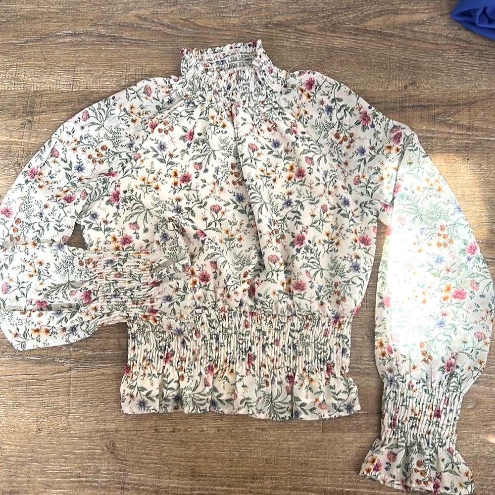Floral top with ruched neck, wrists, and waist.